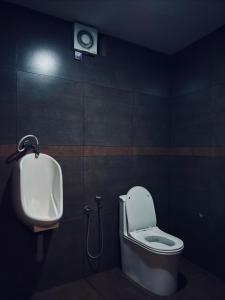 a bathroom with a toilet and a urinal and a sink at Igloo Stays Edapally in Cochin