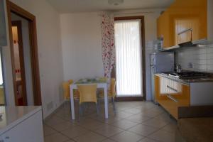 Una cocina con una mesa y sillas en una cocina. en Villaggio Tulipano, en Bibione 4 fotos más