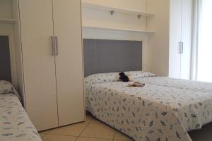 Un gato sentado en una cama en un dormitorio. en Villaggio Tulipano, en Bibione