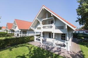 a large white house with a large window at Holiday Park Dennenbos in Oostkapelle