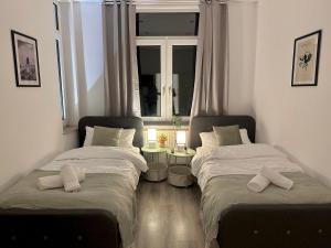 two beds sitting in a room with a window at Harmony Home - inkl Balkonen - TV Streaming - uvm in Bremerhaven