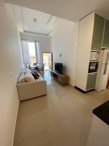 a living room with a couch and a kitchen at Casa confortável perto da praia in Guaratuba