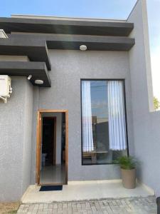 a small house with a window and a potted plant at Casa confortável perto da praia in Guaratuba