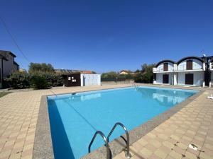 a large blue swimming pool with a building in the background at Isca Dreams T6 in Isca sullo Ionio