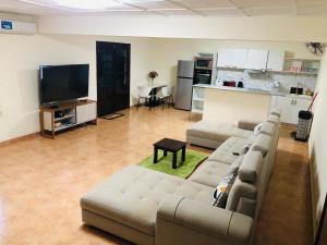 a living room with a couch and a flat screen tv at Villa SAIDIA climatisée avec PISCINE in Diego Suarez