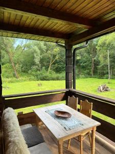 a table and chairs on a porch with a view of a field at Bieszczady ClaraArt in Czarna