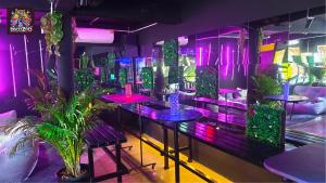 a room with tables and potted plants and purple lights at DISCO ZOO Bar & Hostel in Haad Rin