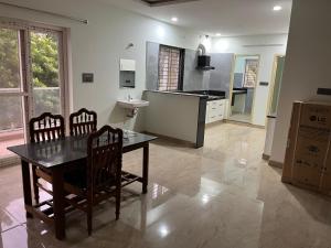 eine Küche mit einem Tisch, 2 Stühlen und einem Waschbecken in der Unterkunft 4C NRI residency in Tirupati