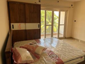 ein Schlafzimmer mit einem Bett und einem großen Fenster in der Unterkunft 4C NRI residency in Tirupati