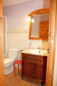 een badkamer met een wastafel, een toilet en een spiegel bij La Media Luna in Segorbe