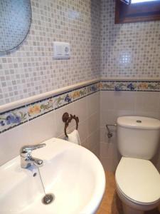 a bathroom with a white toilet and a sink at La Media Luna in Segorbe +17 photos
