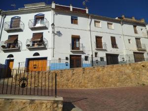 een wit gebouw met balkons en een hek bij La Media Luna in Segorbe