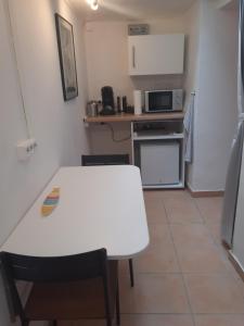 una cucina con tavolo bianco e forno a microonde di Gemütliches Studio-Apartment für 2 Personen in Toplage a Colonia