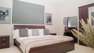 BijiloにあるRelax Water Front Serviced Apartment (Three Bedroom)の大きなベッドとテレビのある寝室