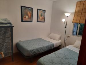 a room with two beds and two pictures on the wall at Apto a 2 minutos de playa. in Fuengirola