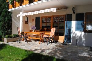 eine Terrasse mit einem Holztisch und 2 Stühlen in der Unterkunft Appartementhaus Königstraße Ferienwohnung Linderhof in Füssen + 4 Fotos