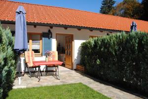 a patio with a table and an umbrella and a house at Appartementhaus Königstraße Ferienwohnung Hohenschwangau in Füssen