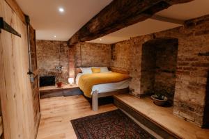 a bedroom with a bed in a brick wall at Lyde Court Country House in Hereford