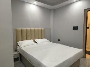 ein Schlafzimmer mit einem großen Bett mit weißen Laken und Kissen in der Unterkunft Hotel Ganesha - residential in Muzaffarpur + 13 Fotos