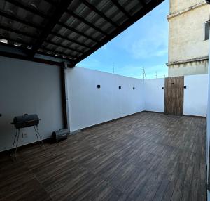 een grote kamer met witte muren en een houten vloer bij Casa de Praia Temporada in Prado