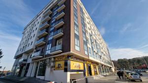a tall building on a city street with people standing outside at cocoluxapartmanl73 in Trnava