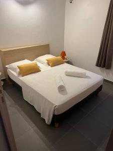 黑角Bungalow coco passion的一间卧室配有带白色床单和黄色枕头的床。