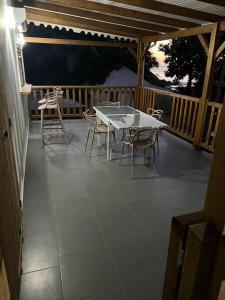 a patio with a table and chairs on a deck at Bungalow coco passion in Pointe-Noire +3 photos