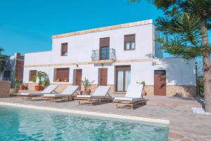 una villa con piscina di fronte a una casa di Lo Mas de Paiall a Deltebre