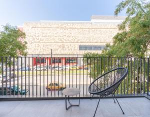 a chair sitting on a balcony with a parking lot at EN Suites Stylish & Comfort Stay near Acropolis in Athens