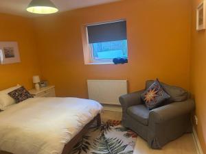 a bedroom with a bed and a chair and a window at Charming Seafront Retreat in Broadstairs