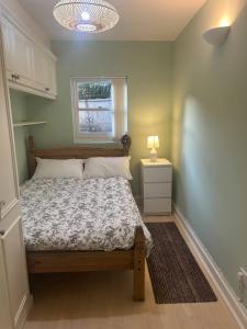 a small bedroom with a bed and a window at Charming Seafront Retreat in Broadstairs