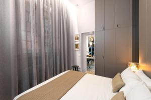 a bedroom with a bed and a window and a desk at Varò Apartment in Taormina