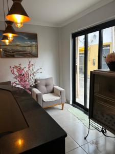 a living room with a television and a chair at Hotel Dallas Ipiranga in Bom Jesus da Lapa