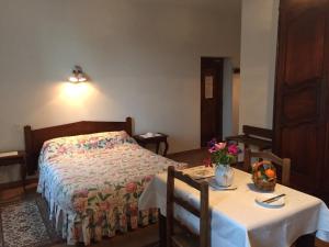 ヴァンスにあるオーベルジュ デ セニョールのベッドルーム1室(ベッド1台、テーブル、椅子2脚付)