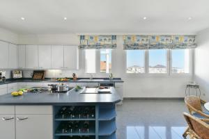 a kitchen with white cabinets and a blue island at Seaview Holiday Rental by VillaGranCanaria in Las Palmas de Gran Canaria