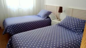 two beds with polka dot sheets in a bedroom at Apartamento Teresa in Pontevedra