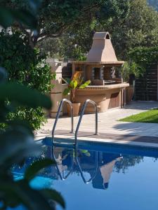a swimming pool in front of a house with a gazebo at Chrissiida Villa in Ialyssos