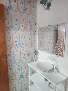 Un baño con espejo y lavabo blanco. en Teixeira e Souza, en Cabo Frío