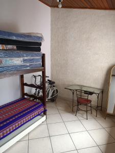 una habitación con una mesa y una litera y una mesa en Teixeira e Souza, en Cabo Frío