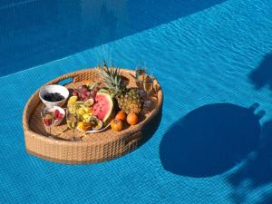 a wooden bowl filled with fruit on top of a pool at Chrissiida Villa in Ialyssos