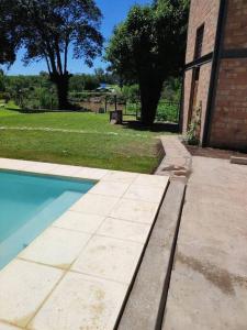 a swimming pool in front of a brick building at Casita Mirador Casai in Oliveros