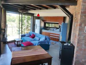 a living room with a blue couch and a kitchen at Casita Mirador Casai in Oliveros