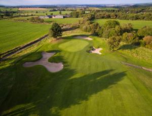 an overhead view of a golf green with two golf carts at Slaley Hall Hotel, Spa & Golf Resort in Slaley