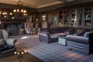 a living room with couches and a fireplace at Slaley Hall Hotel, Spa & Golf Resort in Slaley