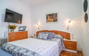 a bedroom with a bed and a flat screen tv at Beautiful Home In Torre De Benagalbón in Torre de Benagalbón +22 photos