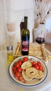 un plato de comida con tomates y una botella de vino en Domusfrumenti, en Oria
