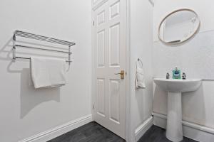 a white bathroom with a sink and a mirror at Mariah Flat - 2 Bedroom getaway in Pontypool in Pontypool +34 photos