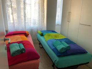 Dos camas con almohadas de colores en una habitación. en Casa Turchese, en Merano