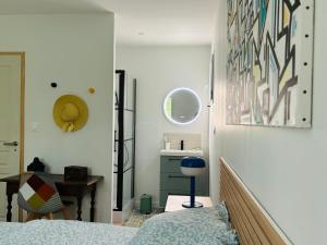 a bedroom with a bed and a desk and a mirror at Maison à 10 min d'Angers in Mûrs-Érigné
