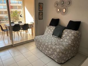 a living room with a bed and a table with chairs at Sète location joli appartement Corniche 4 pers in Sète